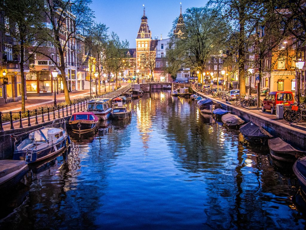 Canals and boats in Amsterdam. Photo via Flickr: Sergey Galyonkin.