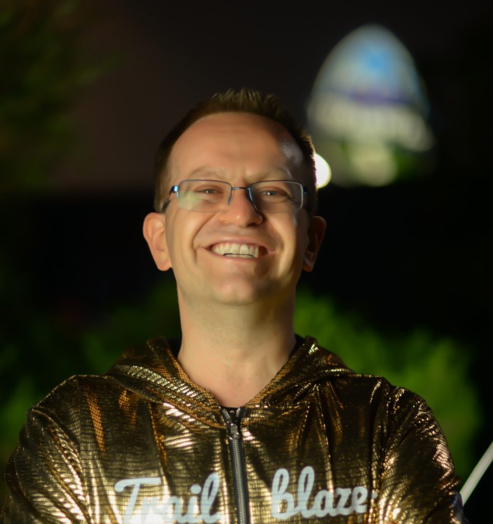 Picture of Paul in his golden hoodie with a huge Trailblazer logo blured but in the background