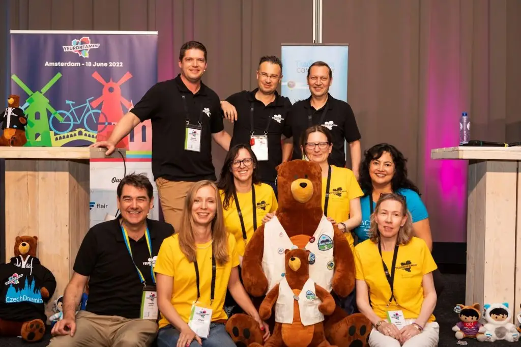 Picture of Codey the bear and the following volunteers: Andre van Kampen, PJ and Jan Vandevelde in the back row; Tanja Janjic, Justyna Krajewska and Marisa Hambleton in the middle row; Kevin Jackson, Olga Shirokova and Moira Gallagher in the front row.