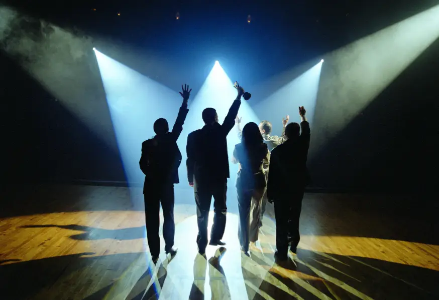 Silhouettes of 5 people celebrating winning an award (with a variety of genders and poses)