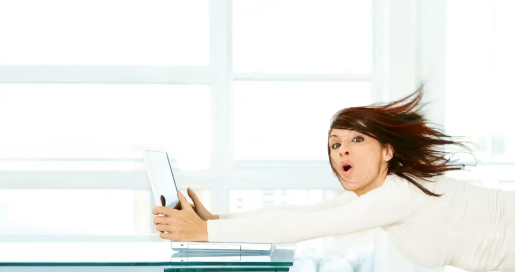 Picture of a women barely clinging on to a laptop whilst being blown away by the wind... inside a room!