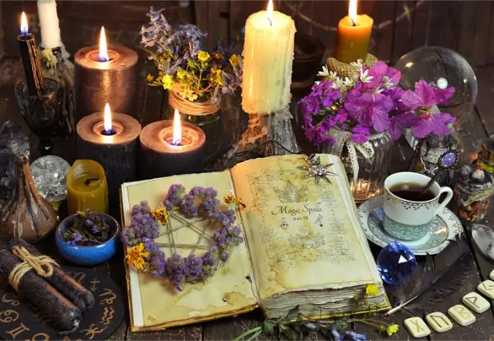 Picture of candles, books, tea and a pentagram